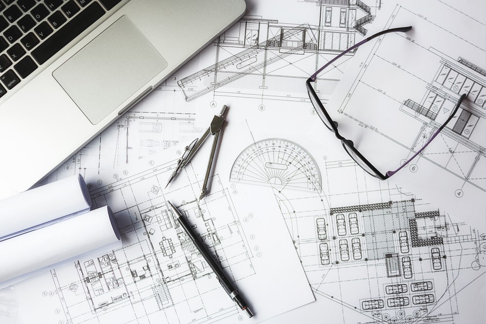 Plans d'ingénierie avec ordinateur, compas et lunettes
